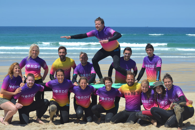 Group surf lesson at Doniños Beach with Nordes Surfhouse instructors.