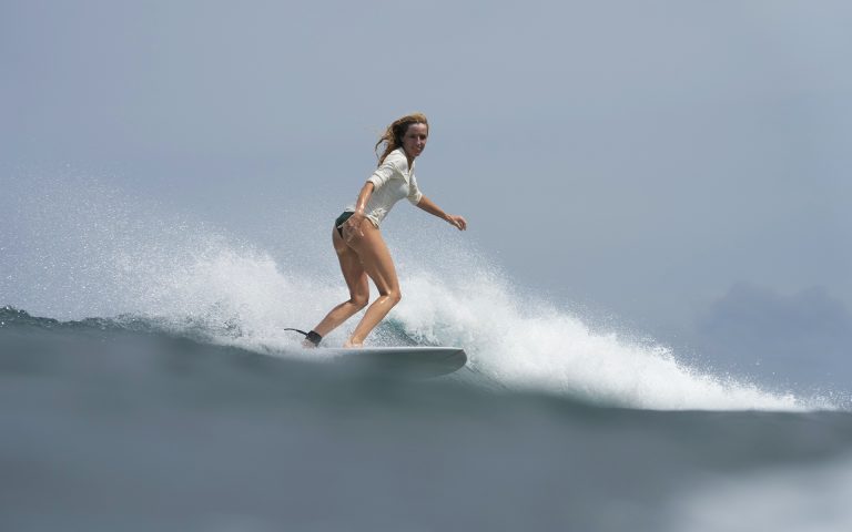 Woman riding a wave on the Maldives Surf Charter 2026 with Nordes Surfhouse in the Central Atolls.