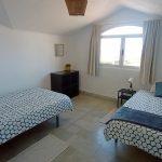 Twin room with two single beds, window light, and clean modern design at Nordes Surfhouse Ferrol