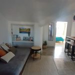 Open lounge with sofa, table, and natural light in Nordes Surfhouse Ferrol Galicia surf accommodation
